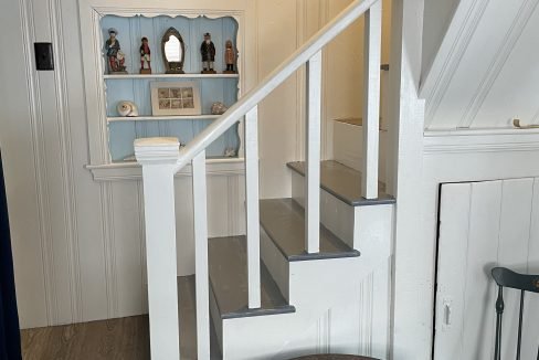 A small room with stairs and a table.