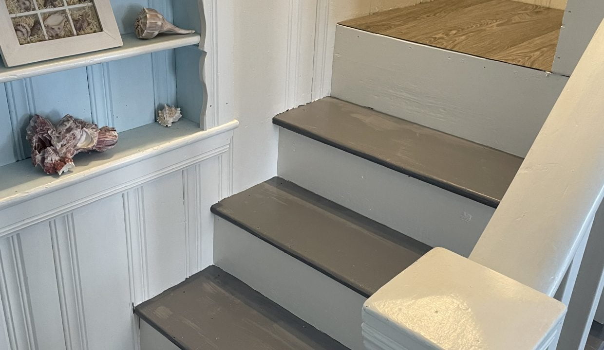 A white stairway with a blue shelf.