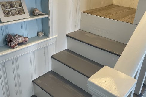 A white stairway with a blue shelf.