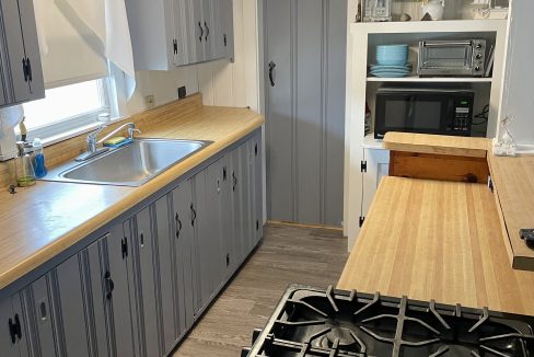 A kitchen with gray cabinets and a stove.