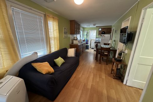 A living room with a couch and a refrigerator.