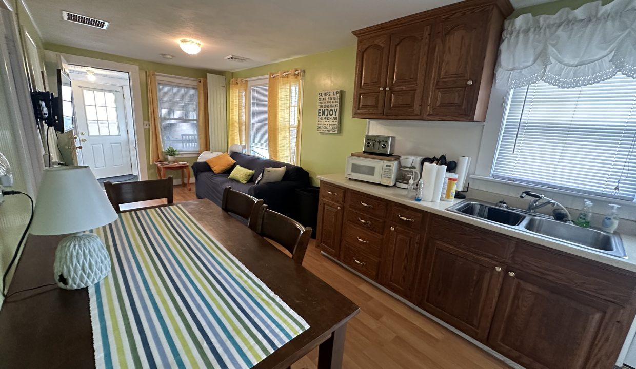 A kitchen with a table and chairs and a refrigerator.