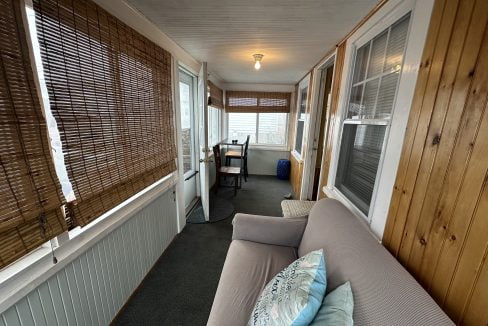 A living room with a couch and a window.