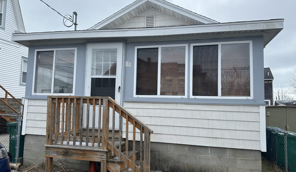 A small house with a porch and steps.