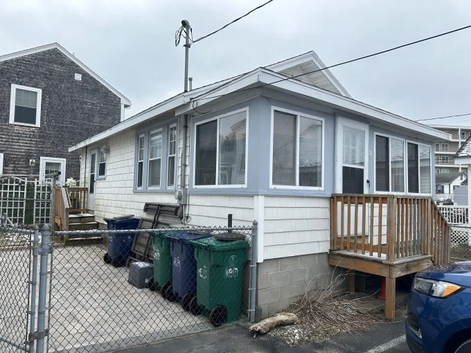 A house with a garbage can in front of it.