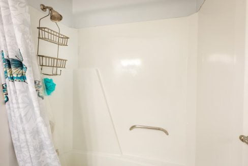 A white bathroom with a shower curtain and a towel.