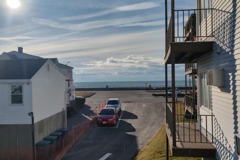 A view of the ocean from the balcony of an apartment building.