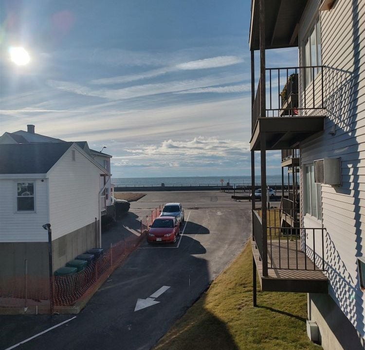 A view of the ocean from the balcony of an apartment building.