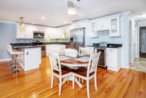 A kitchen with white cabinets and a table.