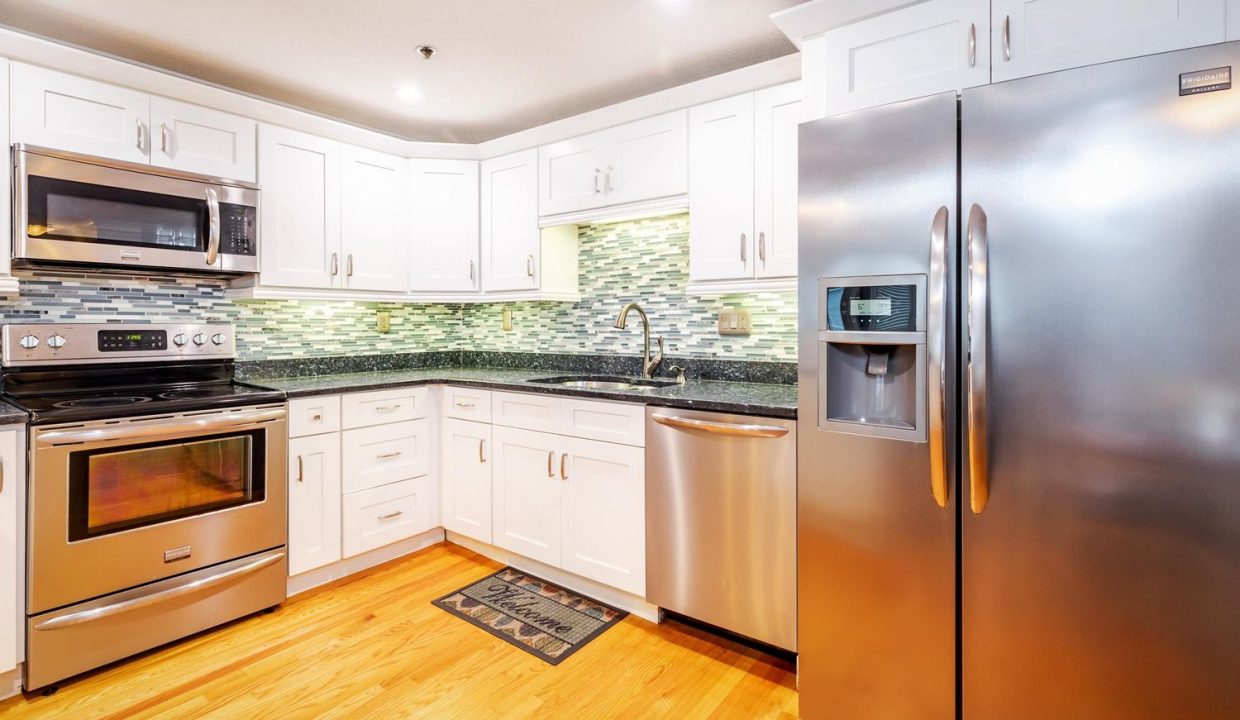 A kitchen with white cabinets and stainless steel appliances.