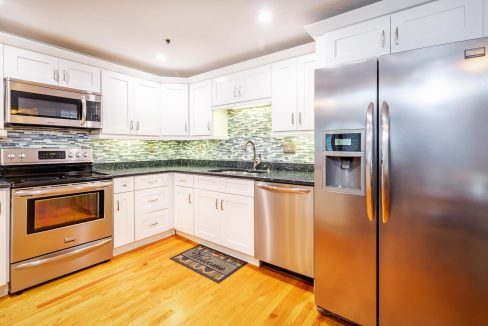 A kitchen with white cabinets and stainless steel appliances.