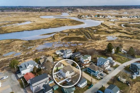 Aerial view of a residential area adjacent to a coastal wetland ecosystem.
