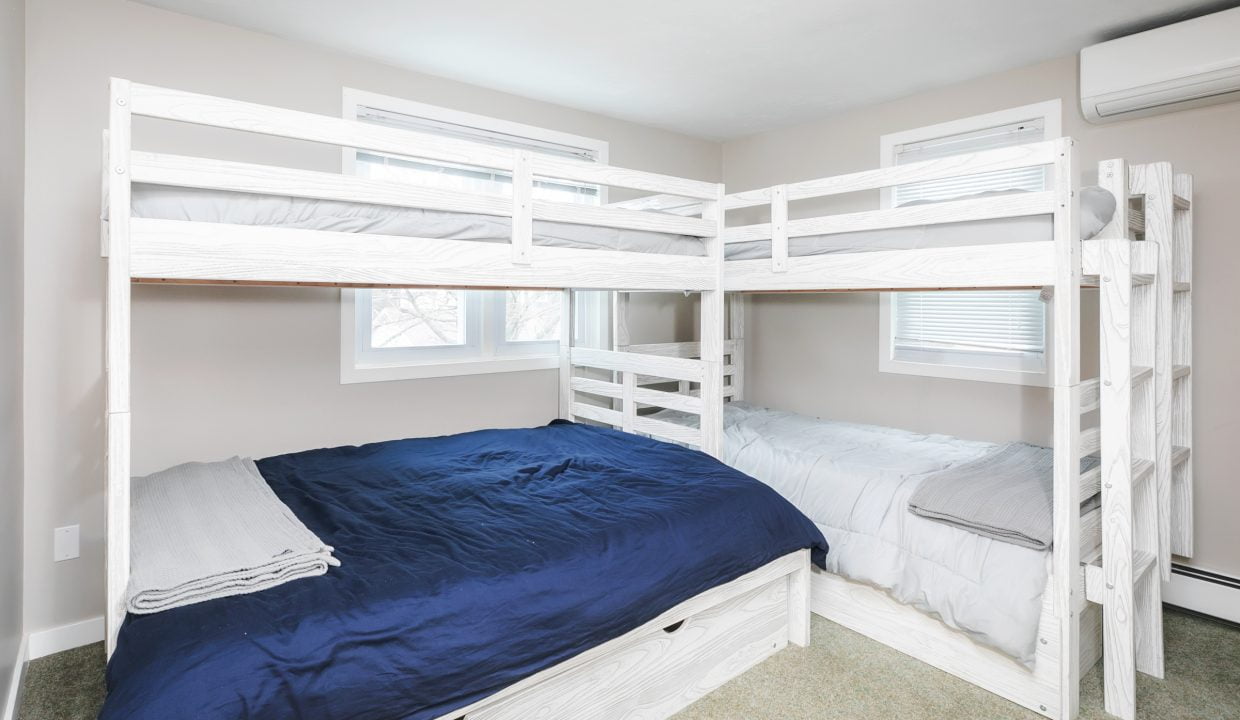 Three bunk beds in a room with a window.