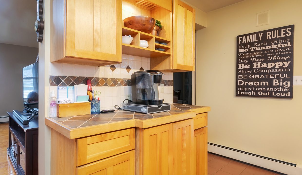 A kitchen with wooden cabinets and a coffee maker.