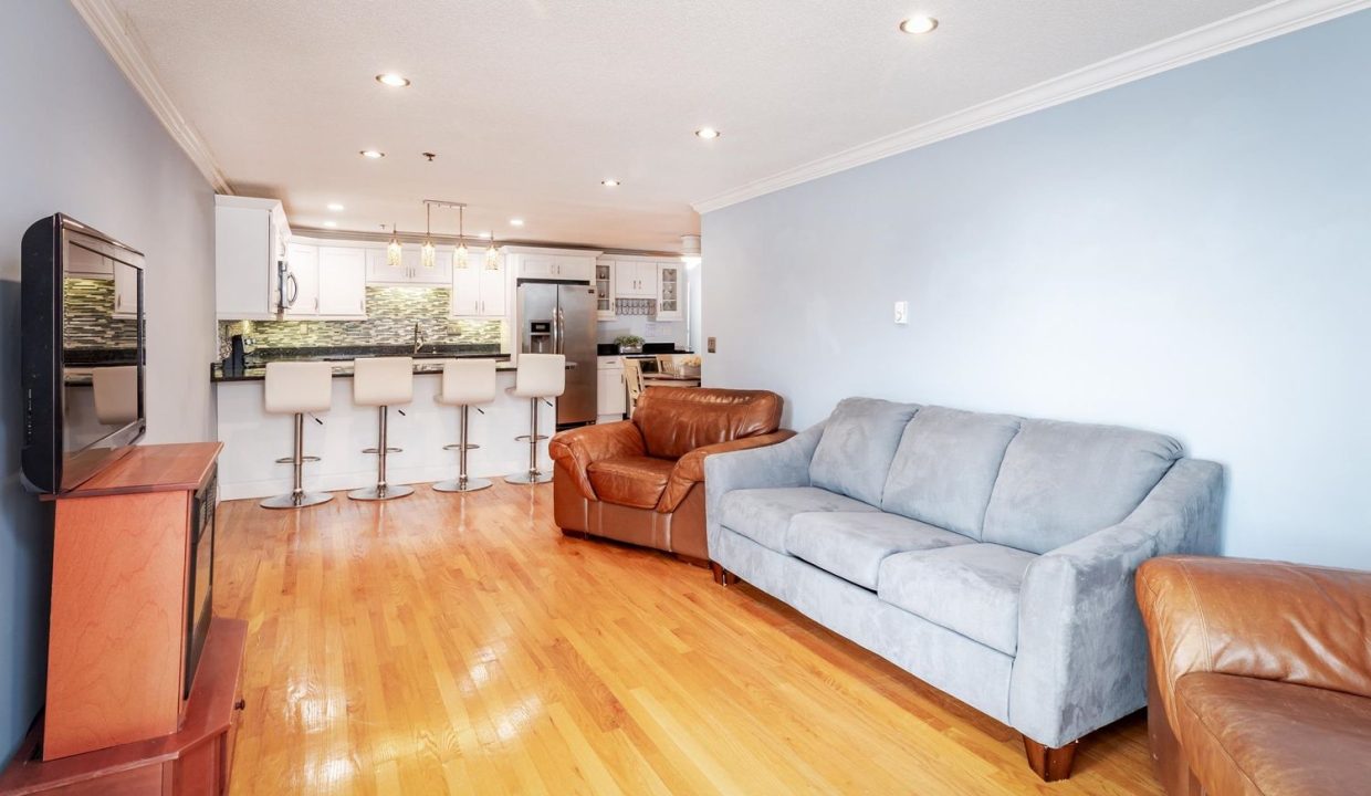 A living room with a couch and kitchen.