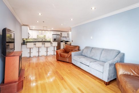 A living room with a couch and kitchen.