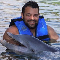 A man in a life jacket with a dolphin.
