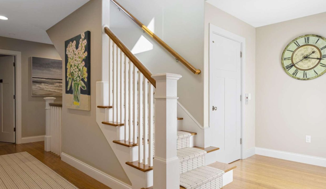 Modern home interior with wooden staircase and neutral color palette.