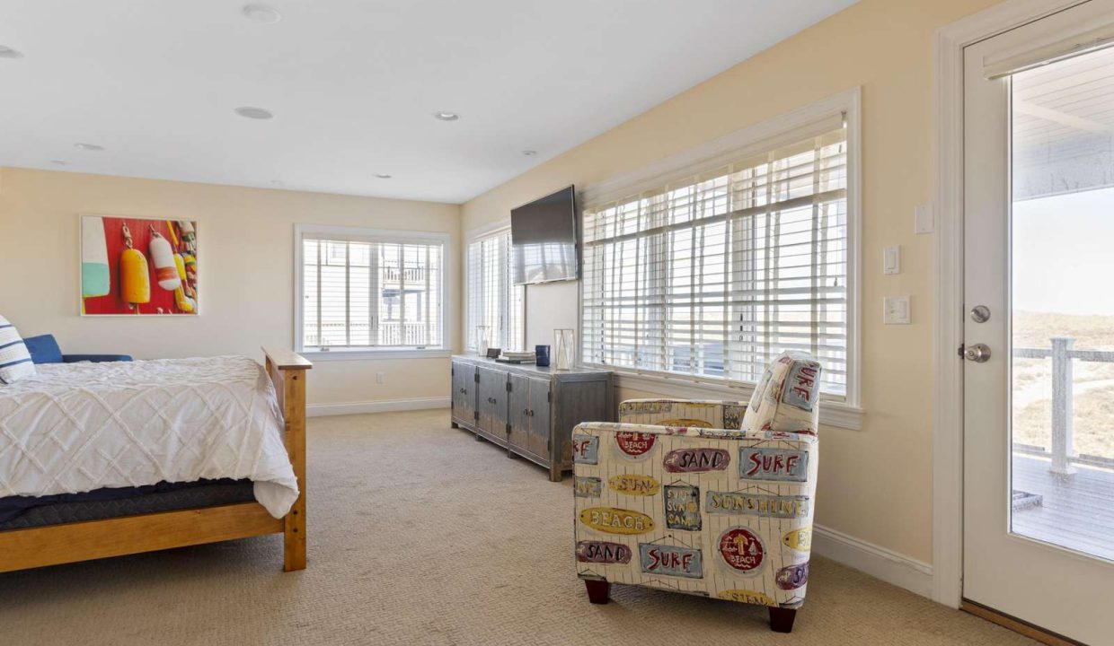 Bright and airy bedroom with beach-themed decor and access to a balcony.