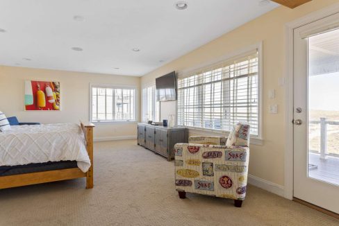 Bright and airy bedroom with beach-themed decor and access to a balcony.