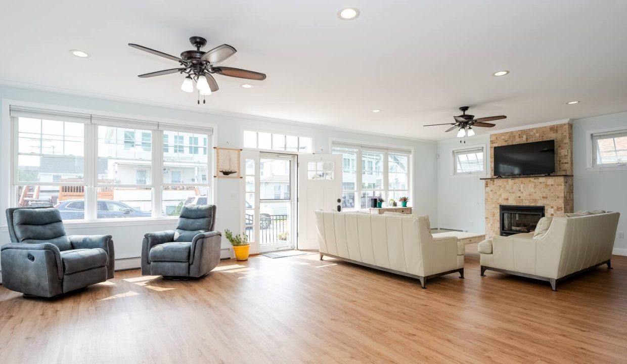 Spacious living room with modern furnishings, hardwood floors, and ample natural light.