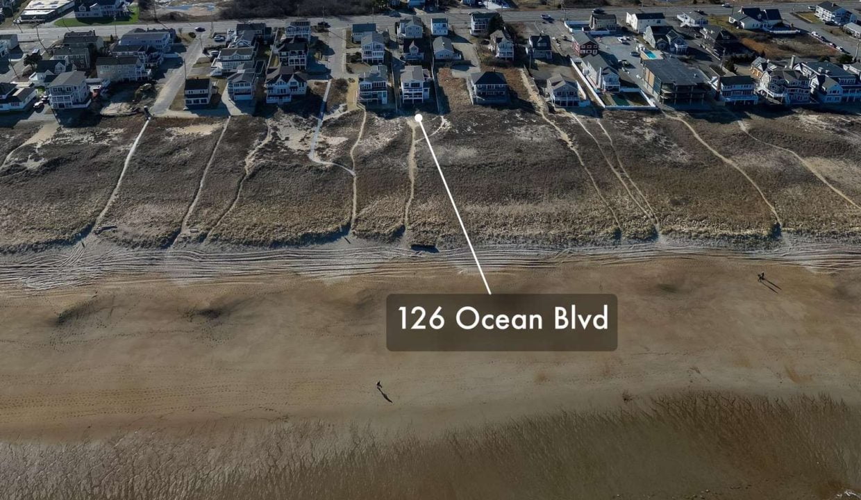 Aerial view of a beachfront neighborhood with the address 126 ocean blvd marked on the sandy shore.