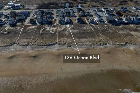 Aerial view of a beachfront neighborhood with the address 126 ocean blvd marked on the sandy shore.