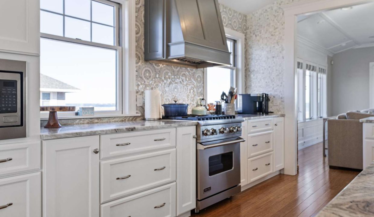 Modern kitchen interior with white cabinetry and stainless steel appliances.