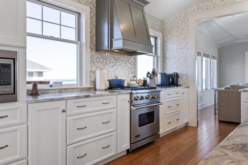 Modern kitchen interior with white cabinetry and stainless steel appliances.