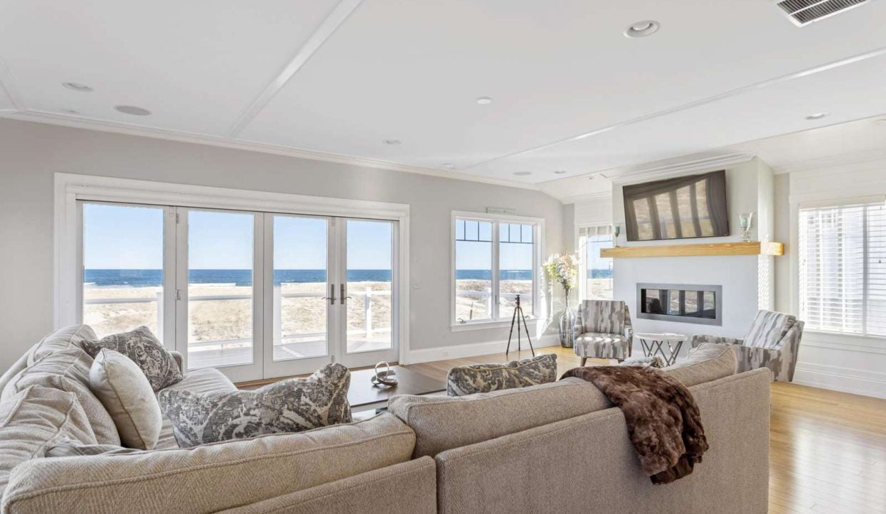 Bright living room with large windows overlooking the beach.