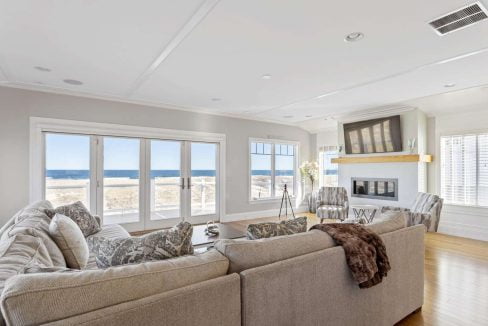 Bright living room with large windows overlooking the beach.