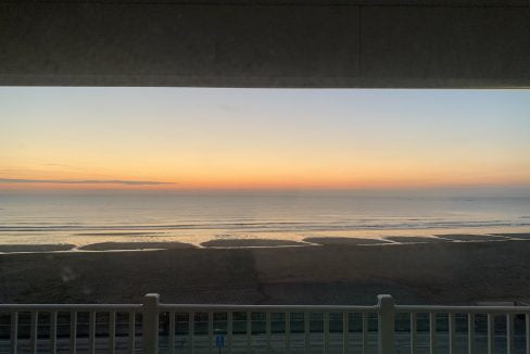 Sunset view over a beach from a balcony.