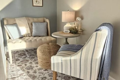 Cozy reading nook with a striped armchair, side table, and warm lighting.