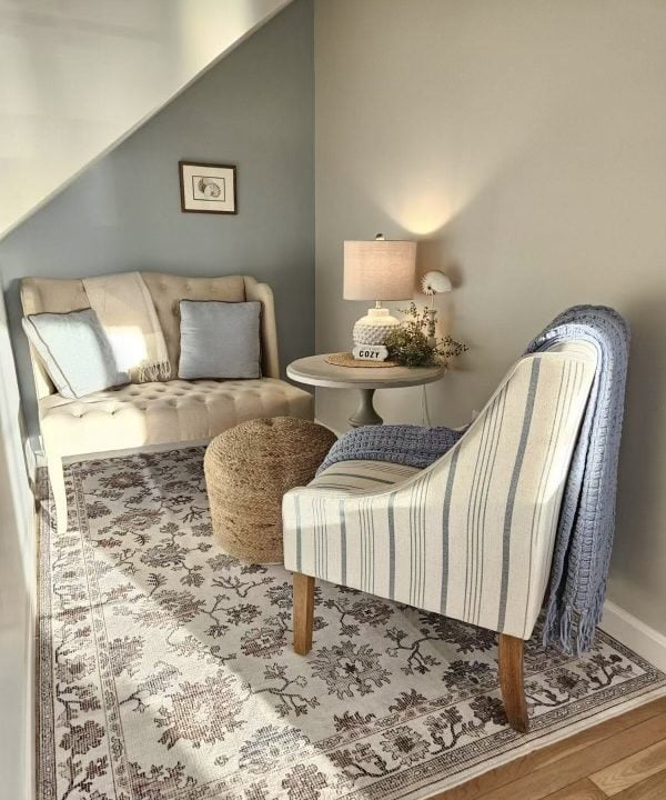 Cozy reading nook with a striped armchair, side table, and warm lighting.